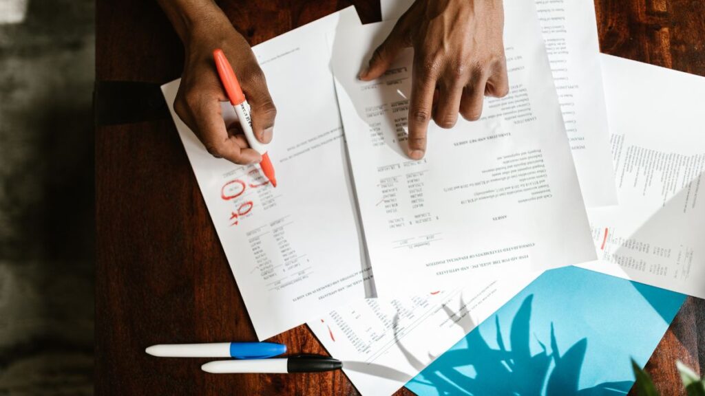 Hands sorting through financial trust documents and statements