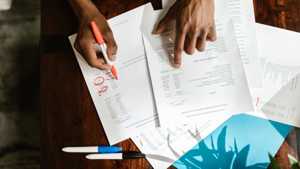 Hands sorting through financial trust documents and statements