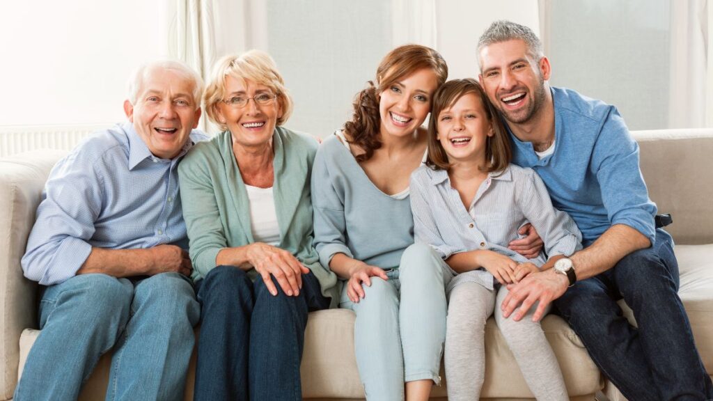 Multigenerational family seated on a couch, smiling and connected