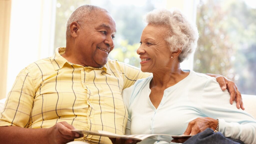 Smiling older woman and man in conversation, relaxed at home