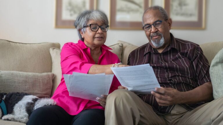 Older couple reviewing tax documents together on the couch