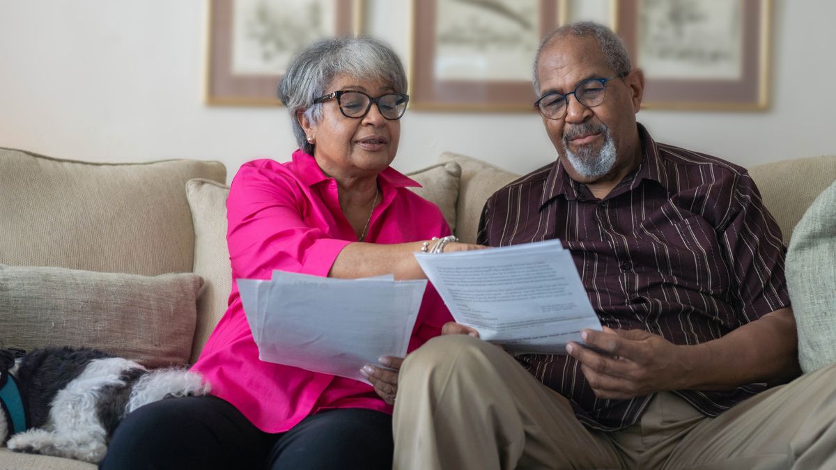 Older couple reviewing tax documents together on the couch