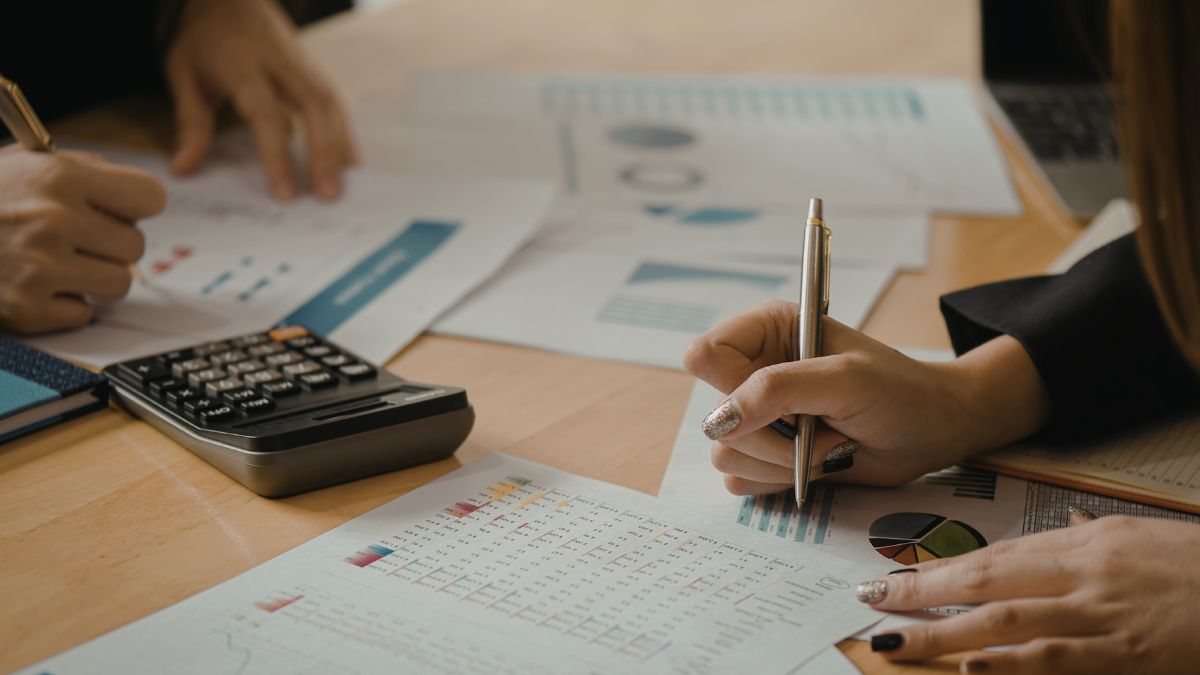Close-up of professionals reviewing financial charts and documents, symbolizing coordinated cross-border wealth planning.