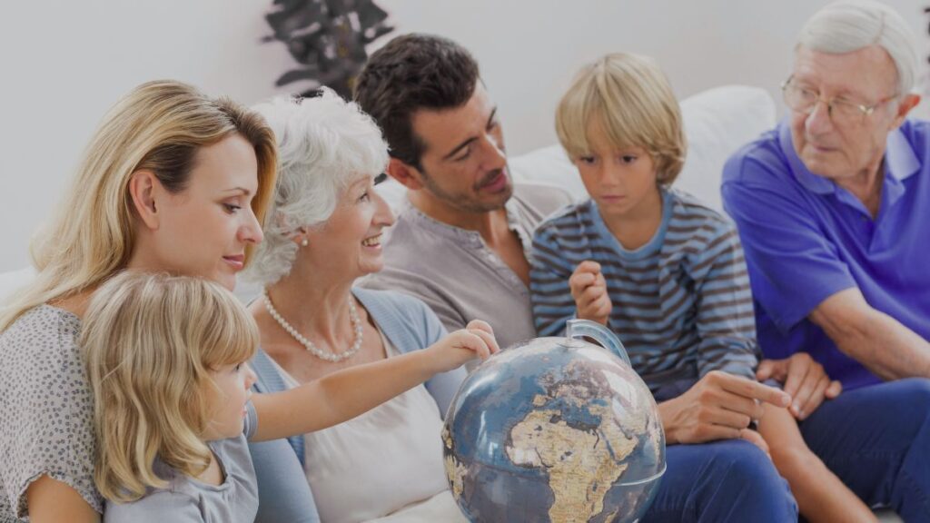 Multi-generation family gathered around a globe, representing coordinated global legacy and wealth planning.