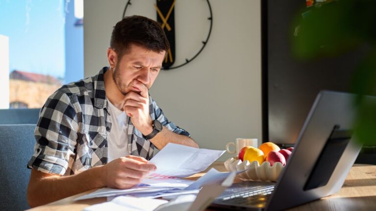 Man reviewing financial documents and planning decisions at home
