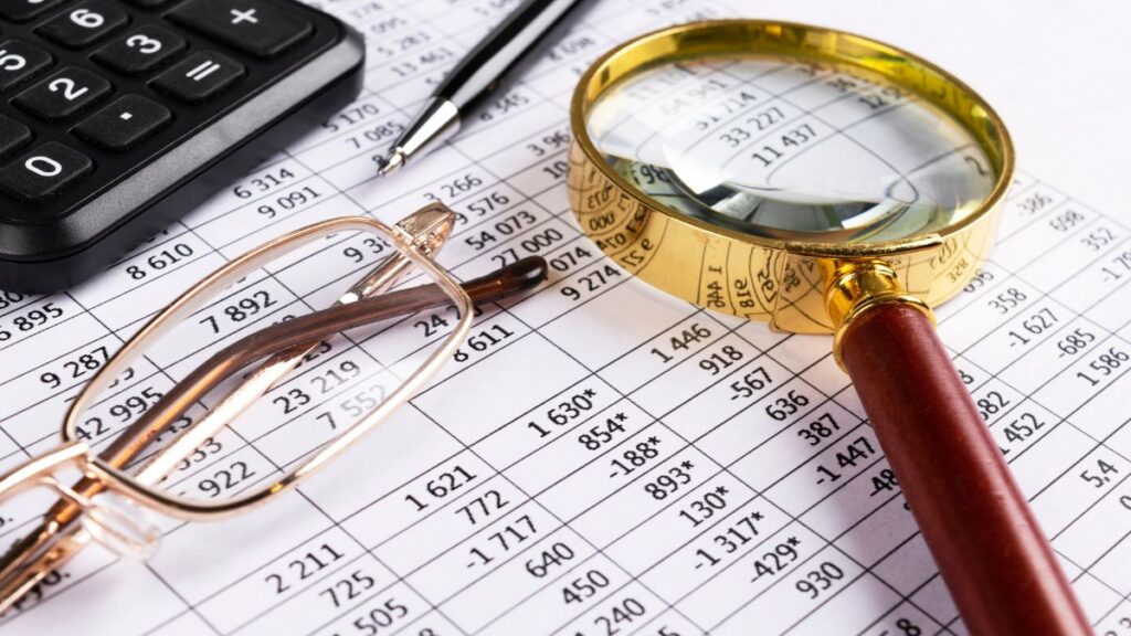Magnifying glass and calculator over financial records