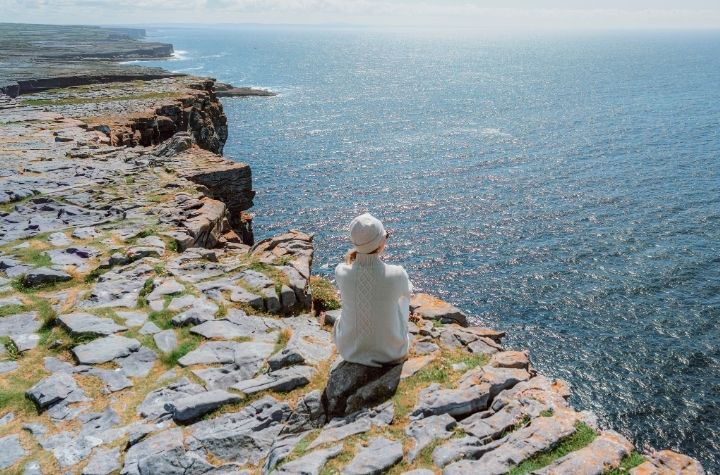 Woman overlooking the Atlantic coast in Ireland